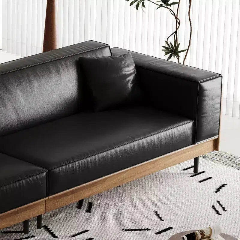 Divano moderno in pelle largo 270 cm con struttura in legno massello, gambe in metallo e 3 cuscini decorativi, nero